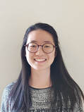 Headshot of Crispy smiling in front of a blank background