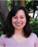 Headshot of Erika against a background of trees