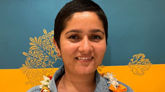 Headshot of Ishwora in front of a blue and yellow background with floral designs