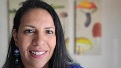 Headshot of Adriana in front of a fungi poster